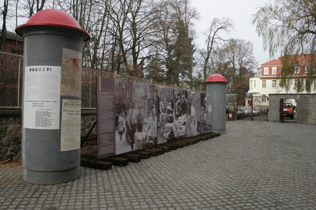 Plenerowa część wystawy z planszami fotograficznymi i informacyjnymi prezentowanymi przed budynkiem muzeum (kliknięcie powiększy zdjęcie).