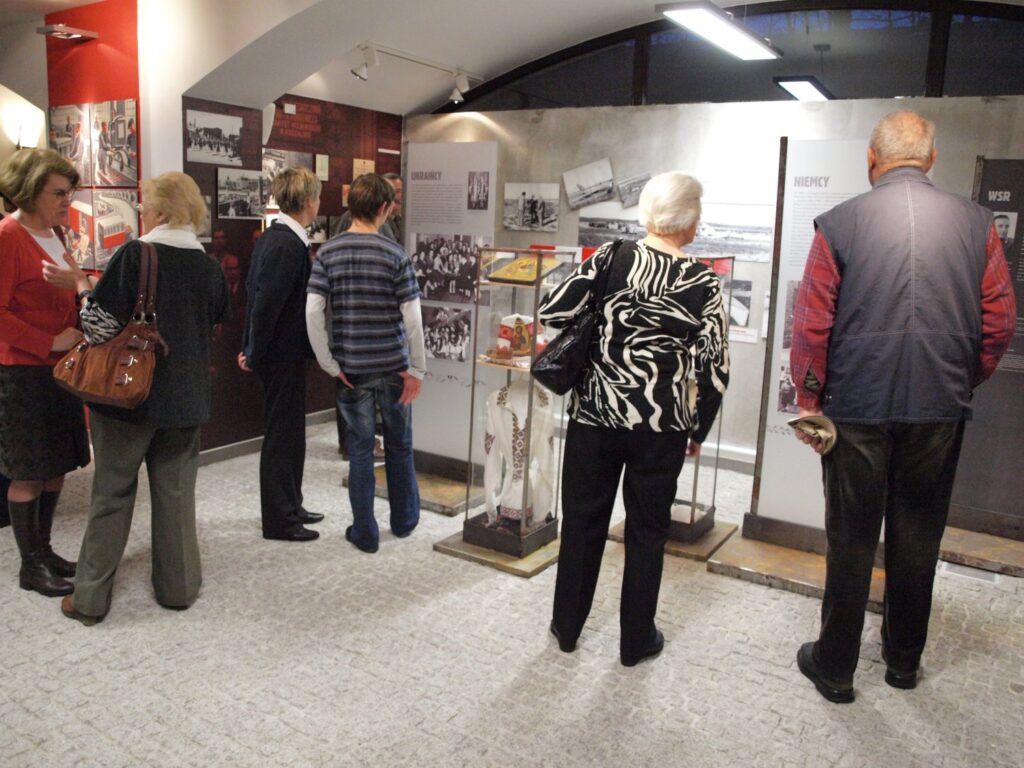 Uczestnicy wernisażu zapoznają się z kolejną częścią ekspozycji prezentującą fotografie, dokumenty i pamiątki historyczne (kliknięcie powiększy zdjęcie).