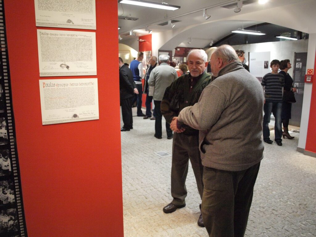 Goście prowadzą rozmowy w przestrzeni ekspozycji podczas zwiedzania wystawy historycznej (kliknięcie powiększy zdjęcie).