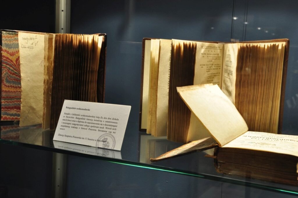 Zabytkowe księgi i dokumenty prezentowane w gablocie jako część ekspozycji historycznej (kliknięcie powiększy zdjęcie).