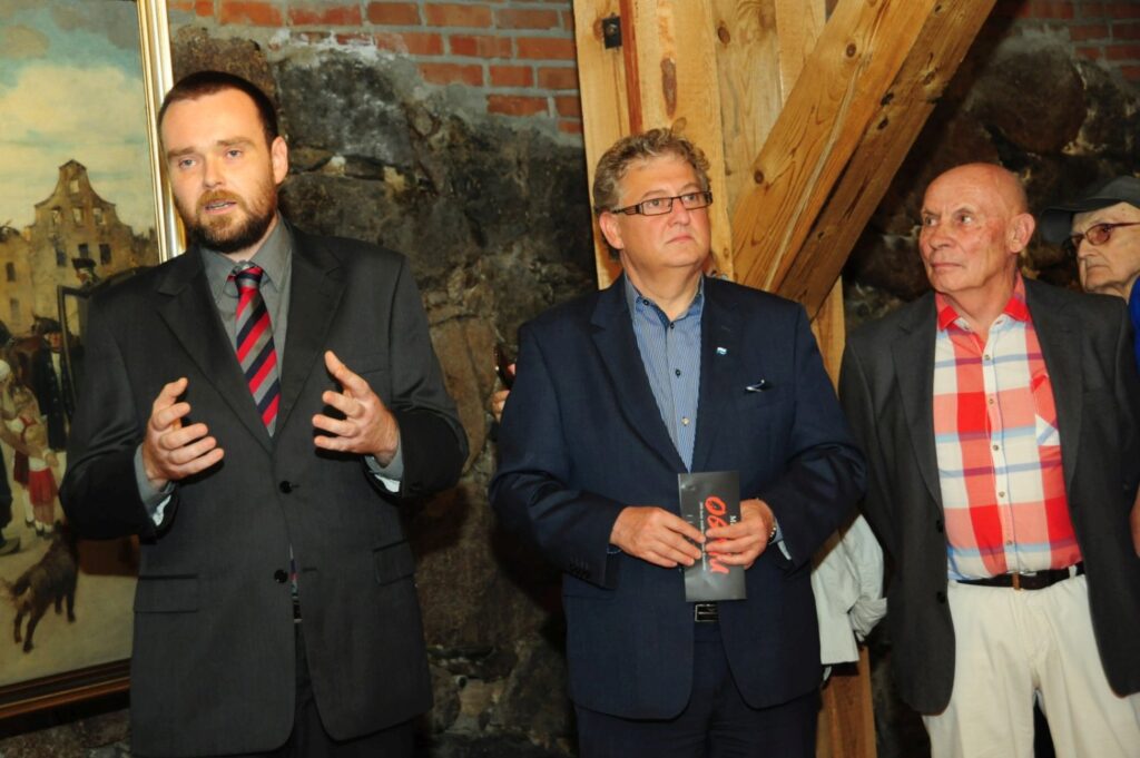 Przemówienie podczas otwarcia wystawy z udziałem organizatorów i zaproszonych gości zgromadzonych w sali ekspozycyjnej (kliknięcie powiększy zdjęcie).