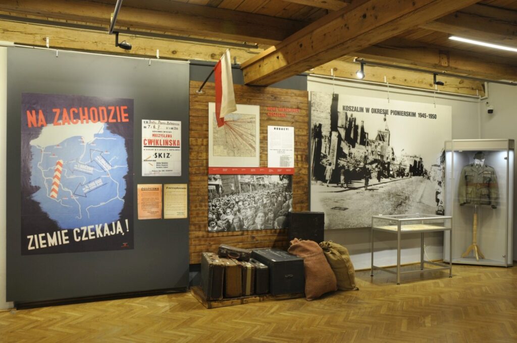 Fragment ekspozycji dotyczącej pierwszych lat powojennych z historycznymi plakatami propagandowymi, fotografiami oraz przedmiotami codziennego użytku umieszczonymi obok plansz opisujących proces odbudowy i zasiedlania miasta (kliknięcie powiększy zdjęcie).