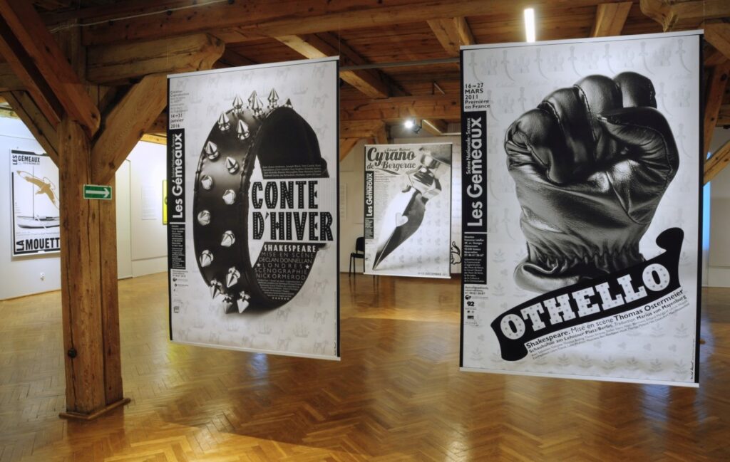 Widok ekspozycji z plakatami przedstawiającymi między innymi „Conte d'hiver” oraz „Othello”; dominują czarno-białe kompozycje typograficzne i fotograficzne zawieszone na tle jasnych ścian (kliknięcie powiększy zdjęcie).
