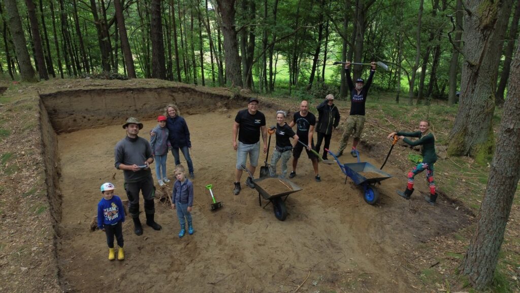 Grupa archeologów i uczestników stoi w wykopie, pozując do zdjęcia po zakończeniu prac (kliknięcie powiększy zdjęcie).