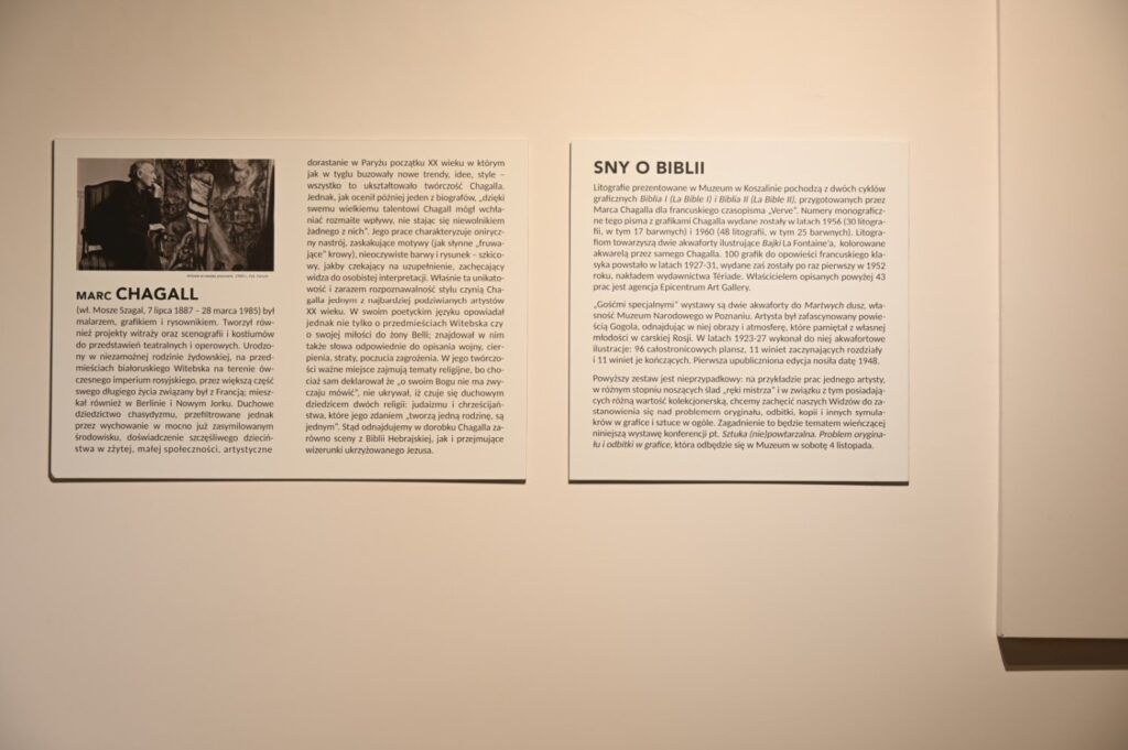 Fragment ściany z dwoma rozbudowanymi tekstami towarzyszącymi wystawie; po lewej stronie znajduje się panel z nagłówkiem „MARC CHAGALL”, zawierający informacje o artyście, a po prawej tekst zatytułowany „SNY O BIBLII”; poniżej i obok widoczny jest fragment dalszej ekspozycji z oprawionymi grafikami; teksty wprowadzają w tematykę prezentowanych prac i ich związki z twórczością Chagalla oraz motywami biblijnymi (kliknięcie powiększy zdjęcie).