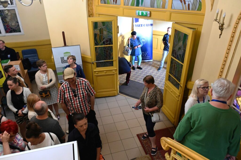 Zwiedzający przemieszczają się przez wejście muzeum, gromadząc się w holu przy otwartych drzwiach (kliknięcie powiększy zdjęcie).