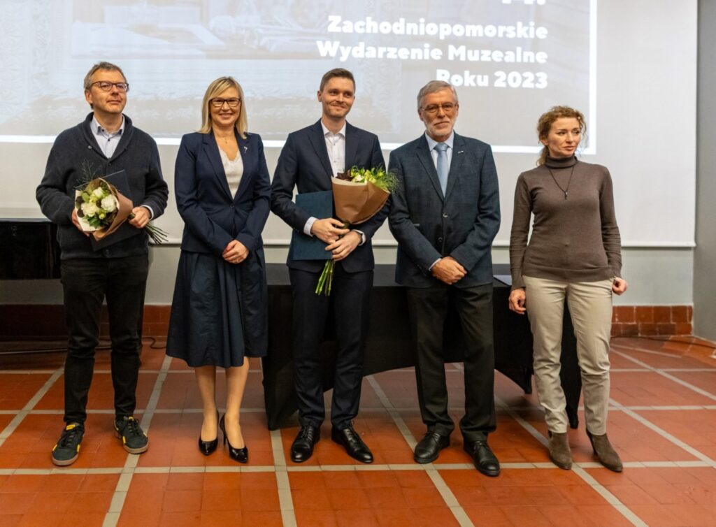 Laureaci stoją na scenie z bukietami kwiatów podczas gali wręczenia nagród (kliknięcie powiększy zdjęcie).