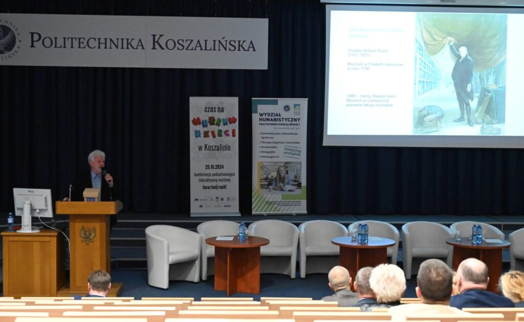 Sala konferencyjna z widownią i sceną, na której wyświetlana jest prezentacja (kliknięcie powiększy zdjęcie).