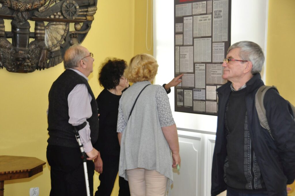 Zwiedzający omawiający prezentowane materiały historyczne podczas wspólnego oglądania wystawy (kliknięcie powiększy zdjęcie).