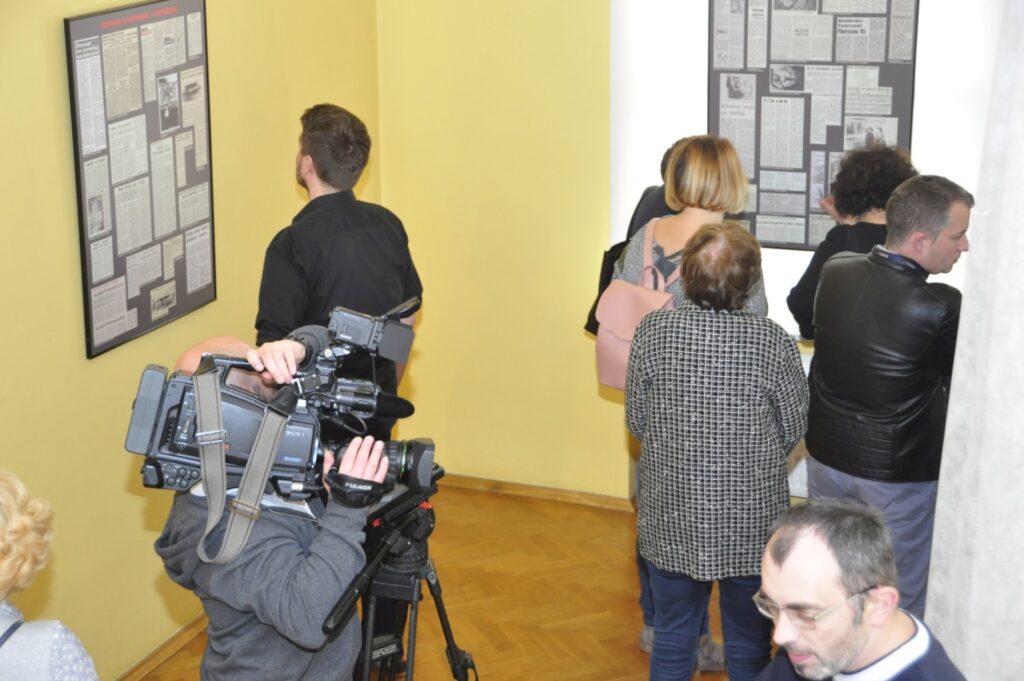Zwiedzający oglądający plansze z dokumentami i materiałami archiwalnymi prezentowanymi na wystawie (kliknięcie powiększy zdjęcie).