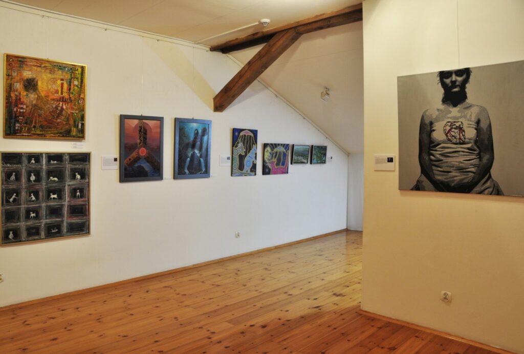 Panorama fragmentu wystawy z pracami malarskimi prezentowanymi w przestrzeni galerii sztuki współczesnej (kliknięcie powiększy zdjęcie).
