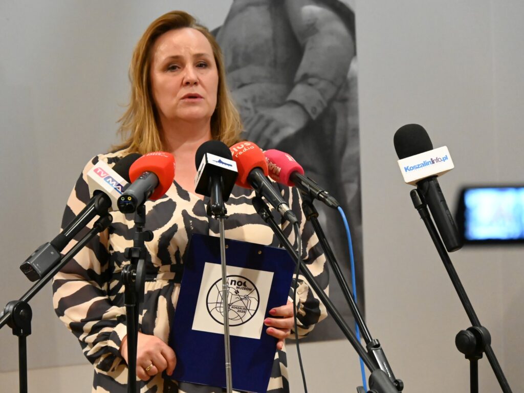 Dyrektor Muzeum stoi przed mikrofonami podczas konferencji prasowej poświęconej "Bezpiecznym Wakacjom 2025".