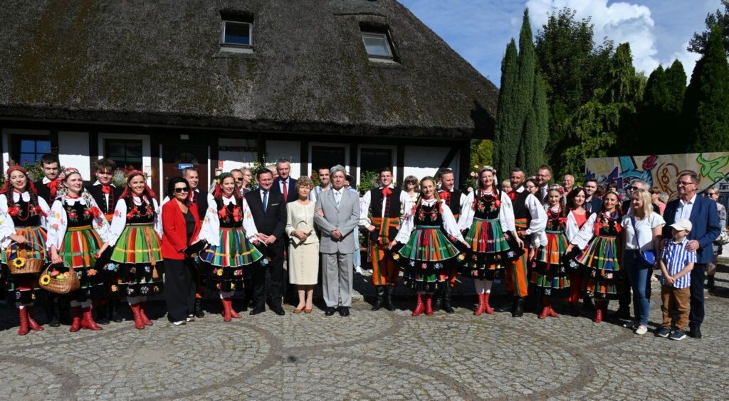 Grupa ludzi pozuje do wspólnego zdjęcia przed budynkiem administracji muzeum (kliknięcie powiększy zdjęcie).