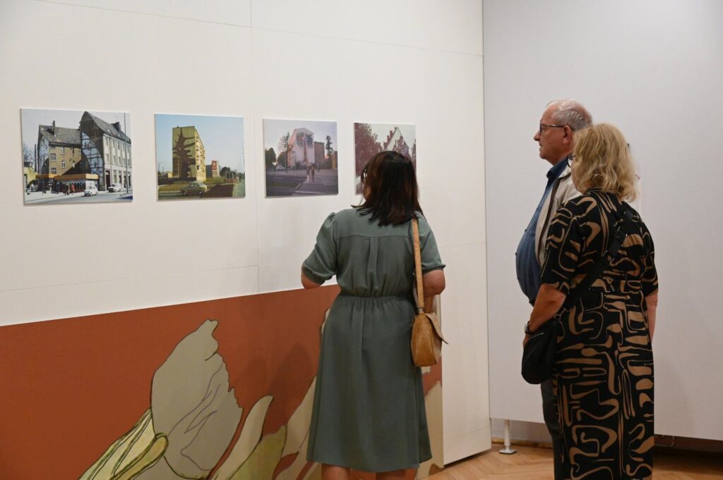 Zwiedzający oglądający fotografie prezentowane na ścianie w galerii muzealnej (kliknięcie powiększy zdjęcie).