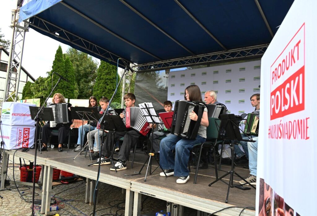 Zespół muzyczny grający na scenie plenerowej, widoczni akordeoniści i instrumentaliści (kliknięcie powiększy zdjęcie).