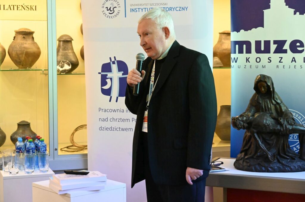 Duchowny przemawia do publiczności podczas konferencji w muzeum (kliknięcie powiększy zdjęcie).