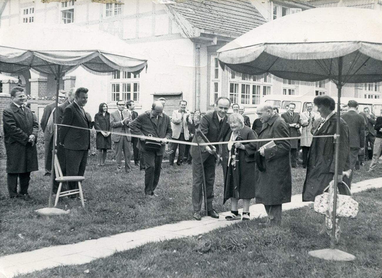 Grupa osób uczestniczy w ceremonii otwarcia, podczas której przecinana jest wstęga (kliknięcie powiększy zdjęcie).