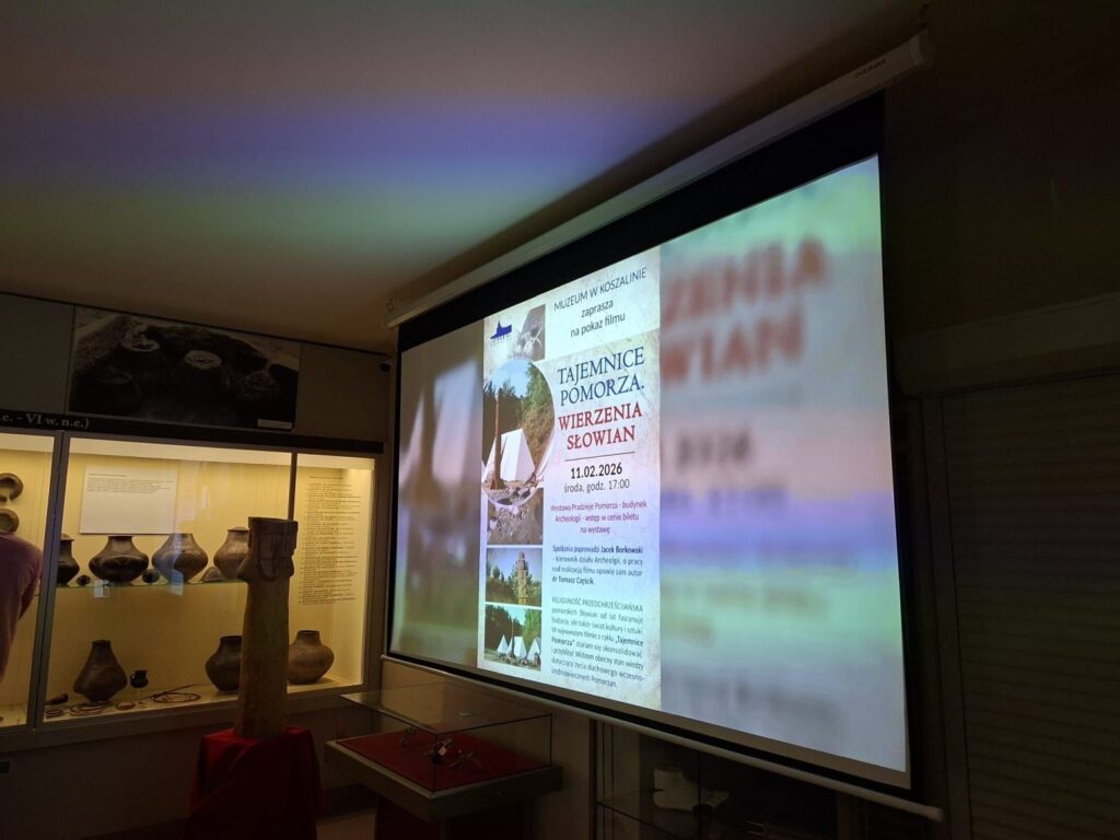 Ekran z wyświetlonym plakatem wydarzenia dotyczącym filmu o dawnych wierzeniach Słowian w sali ekspozycyjnej muzeum (kliknięcie powiększy zdjęcie).