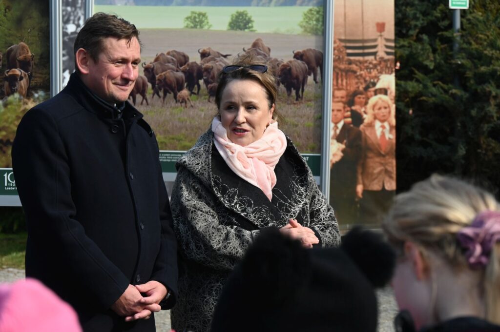 Dyrektor Muzeum Joanna Chojecka i Prezydent Koszalina Tomasz Sobieraj przemawiają do uczestników na tle plansz wystawy plenerowej (kliknięcie powiększy zdjęcie).