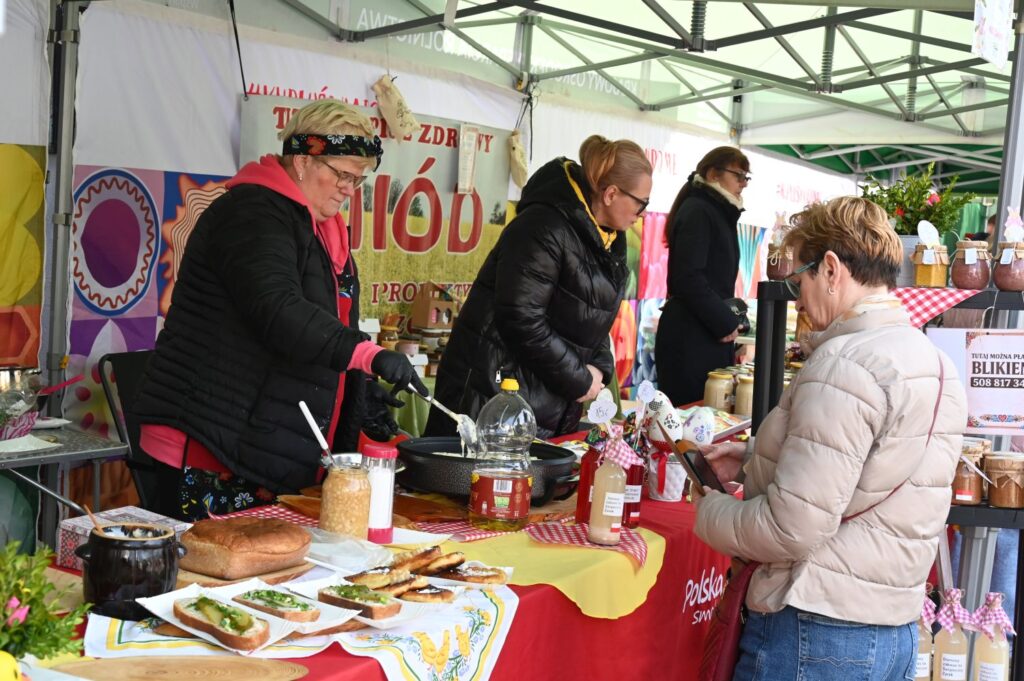 Sprzedawczynie przygotowują i serwują potrawy na stoisku kulinarnym podczas kiermaszu (kliknięcie powiększy zdjęcie).