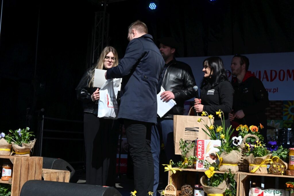 Wręczenie nagrody uczestniczce konkursu na scenie podczas wydarzenia kulinarnego (kliknięcie powiększy zdjęcie).