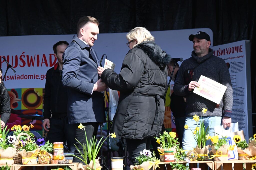 Laureatka konkursu odbiera dyplom i nagrodę na scenie podczas wydarzenia (kliknięcie powiększy zdjęcie).