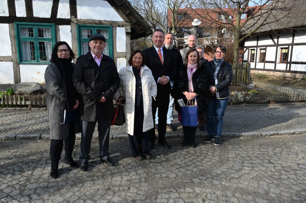 Wspólne zdjęcie delegacji z dyrekcją muzeum i kierownikami działów, przed zabytkowym budynkiem (kliknięcie powiększy zdjęcie).