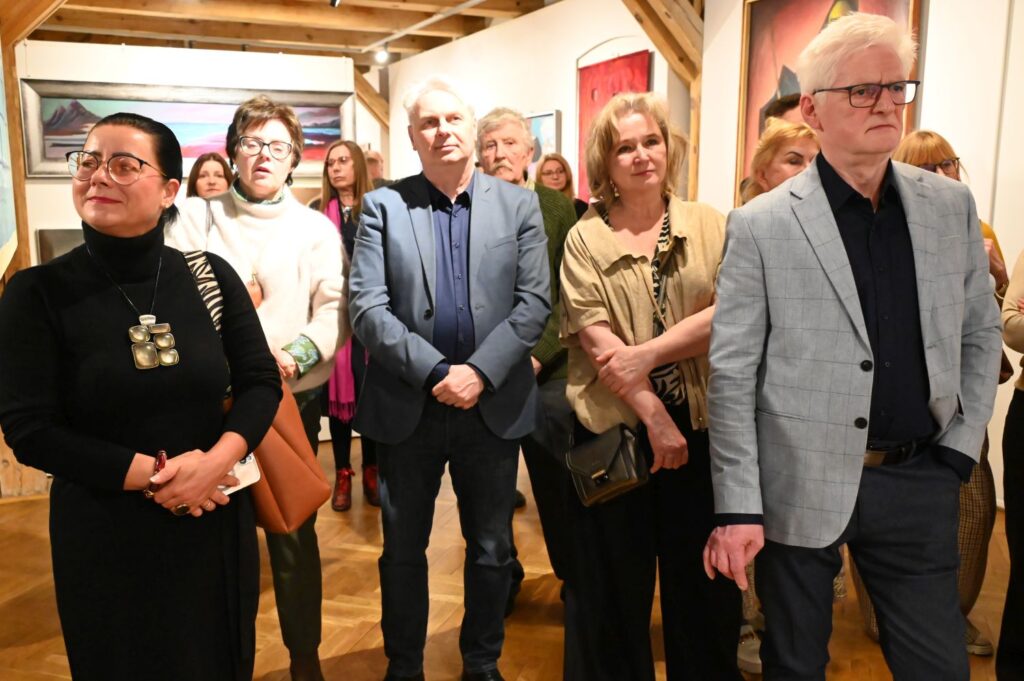 Uczestnicy wernisażu skupieni na przemówieniach wśród prezentowanych prac artystycznych (kliknięcie powiększy zdjęcie).
