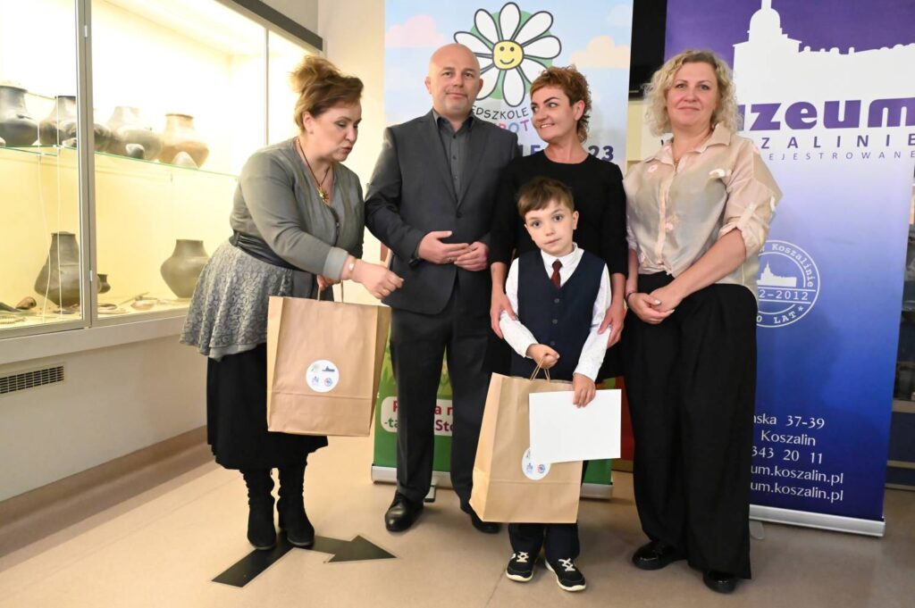 Laureat konkursu pozuje z dyplomem i nagrodą podczas wydarzenia w muzeum (kliknięcie powiększy zdjęcie).