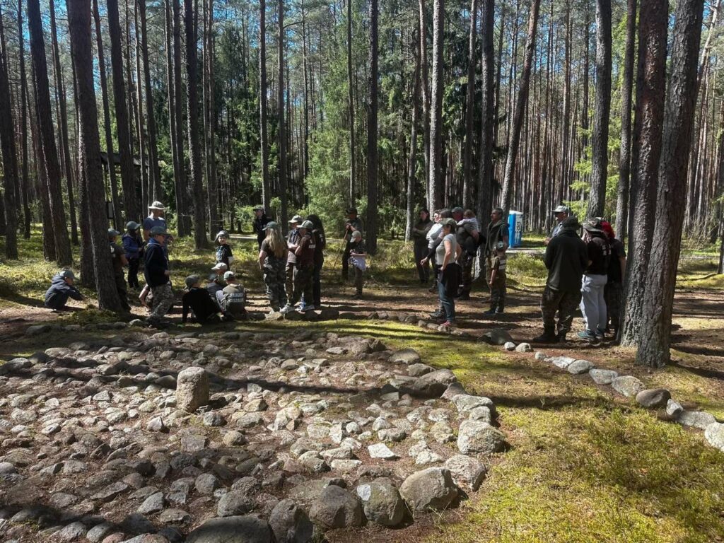 Uczestnicy akcji porządkują teren wokół zrekonstruowanego kamiennego kręgu na stanowisku archeologicznym w Grzybnicy (kliknięcie powiększy zdjęcie).